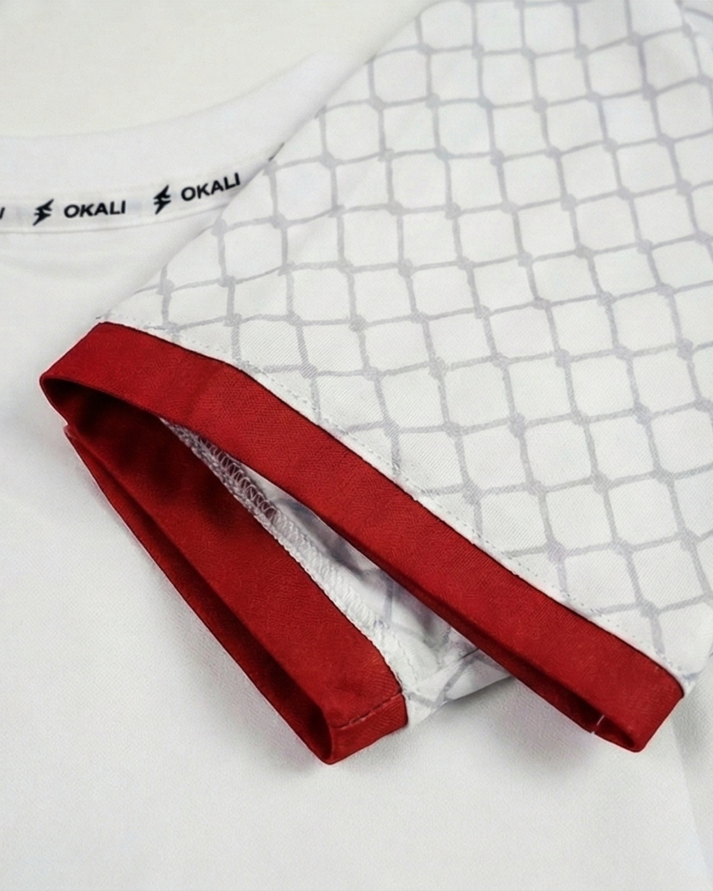 Détail du maillot Palestine Keffieh avec des manches blanches et une finition rouge, symbole de l'identité culturelle.