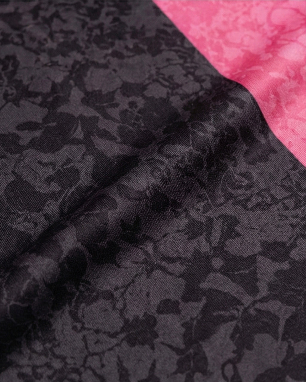 Textile du maillot Palestine noir et rose avec un motif floral sur fond noir et rose.