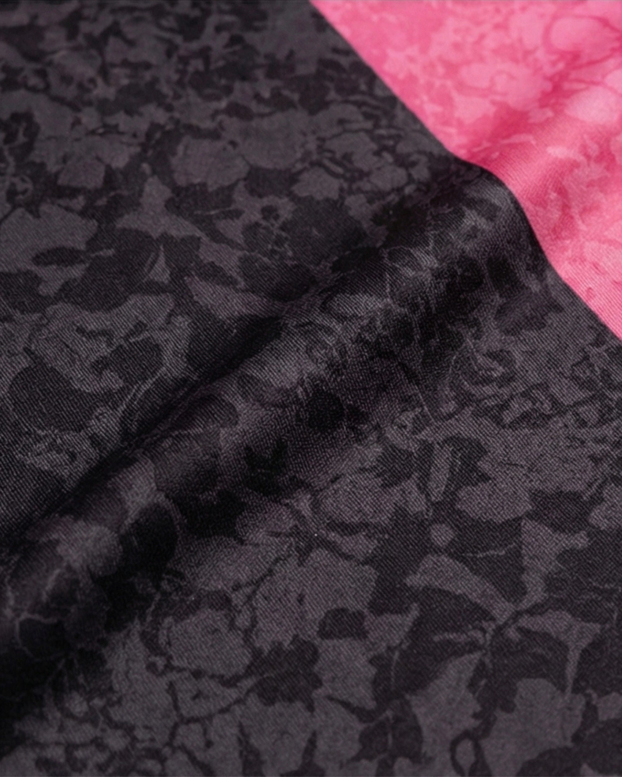 Textile du maillot Palestine noir et rose avec un motif floral sur fond noir et rose.