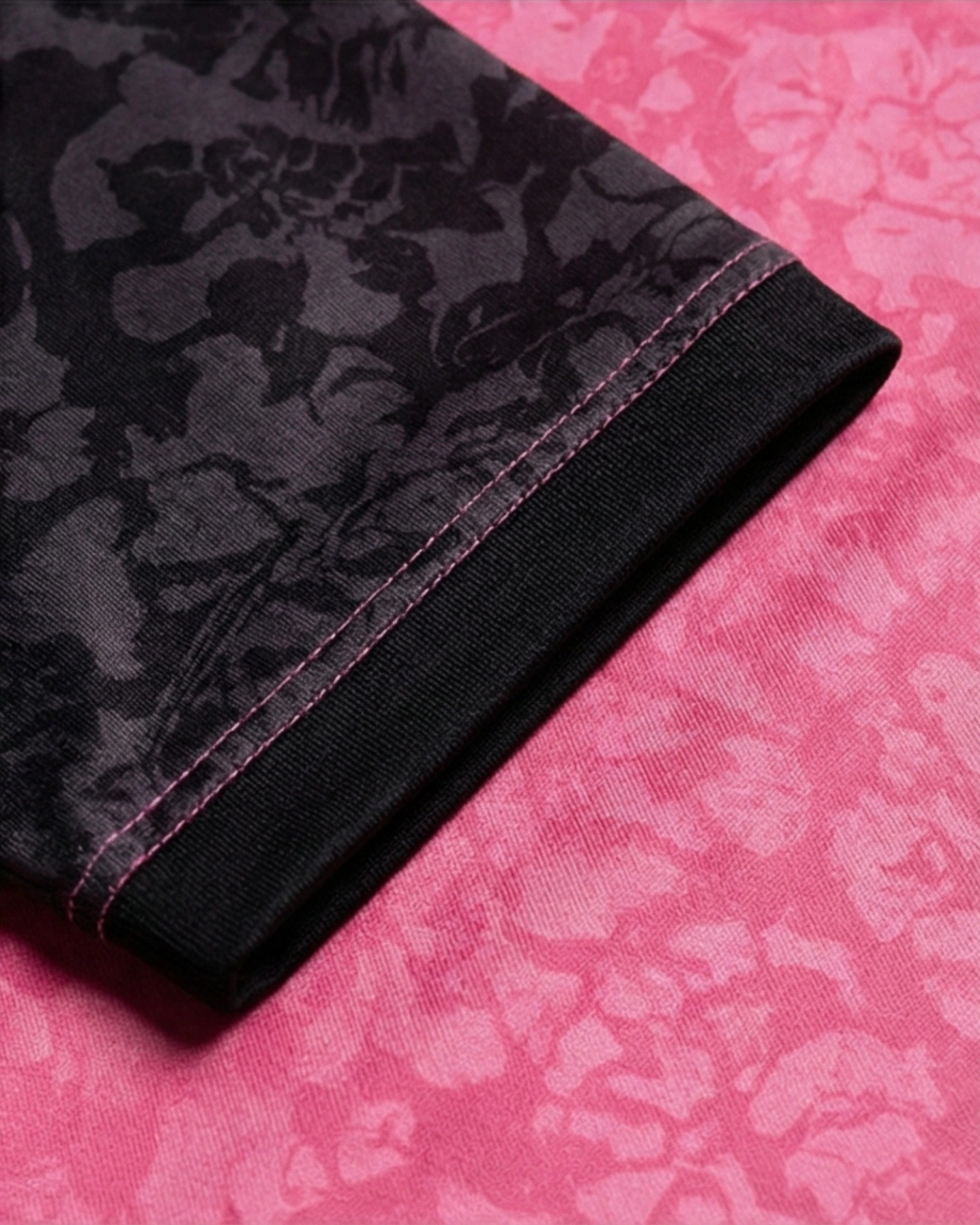 Détail du maillot Palestine noir et rose avec un design floral sur tissu noir et rose.